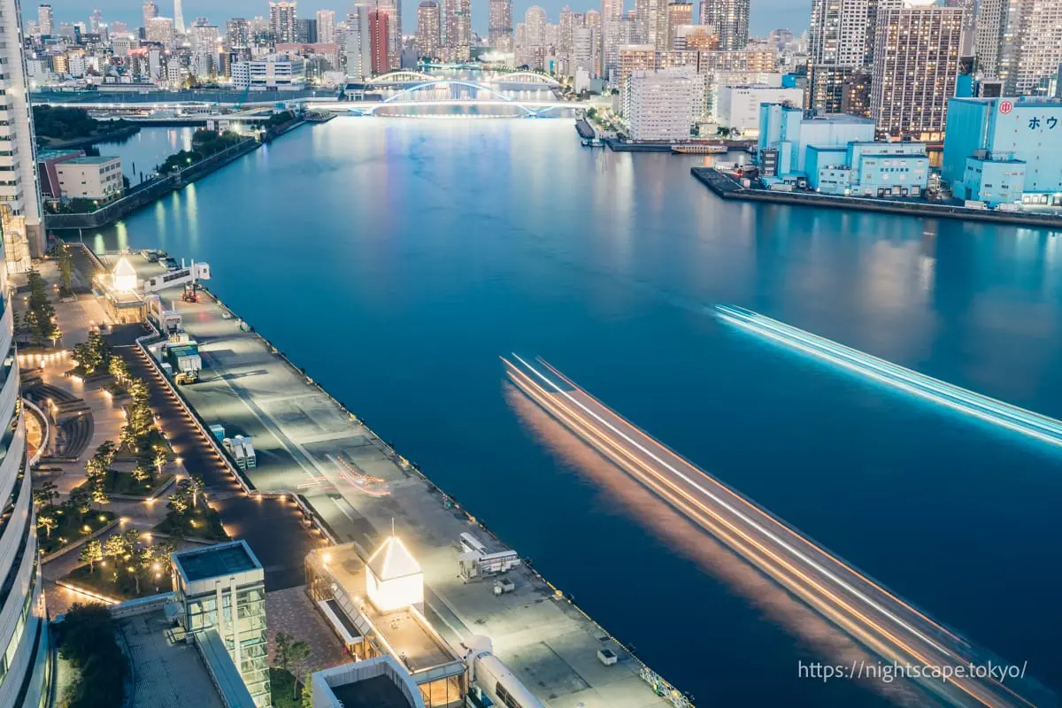 Light trails of cruise boats traveling along the Sumida River